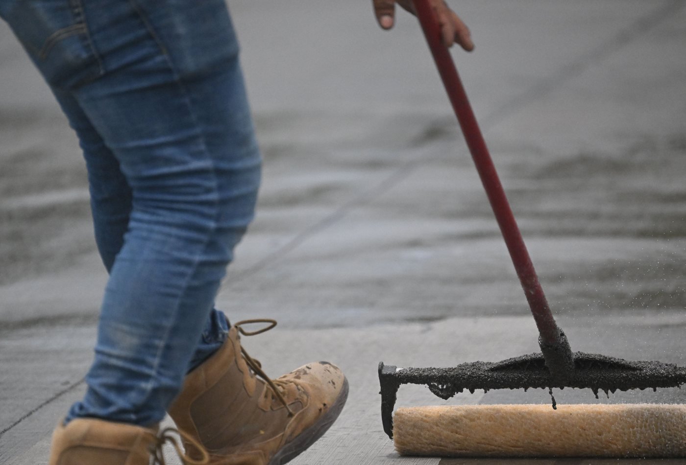 Concrete floor coating being applied with a roller